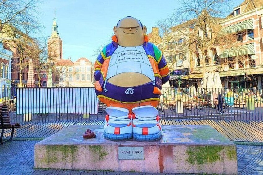 A large sculpture of a character with a colorful outfit and a name plaque. 5