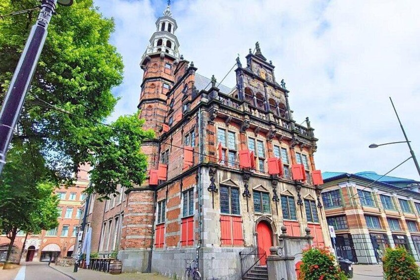 A historic building with a prominent tower and red shutters. 4