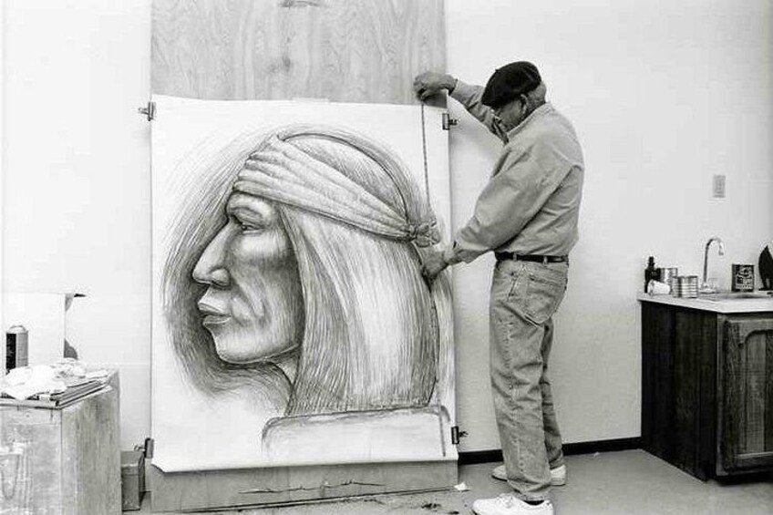 Una persona dibujando un retrato sobre un lienzo grande. 2
