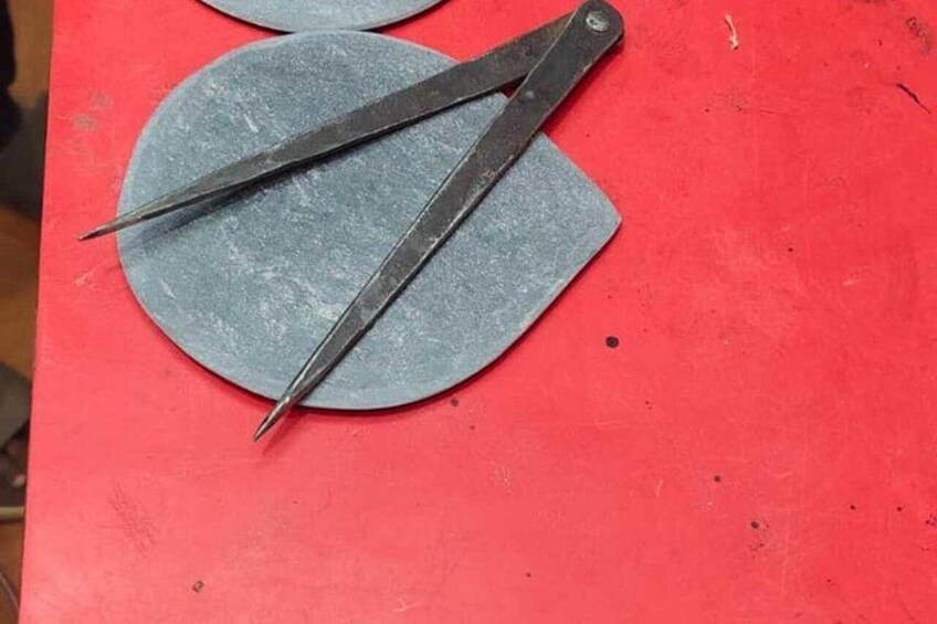 Un par de tijeras sobre una superficie roja con dos objetos circulares. 4