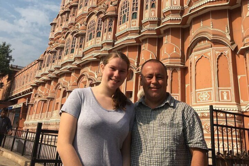 Two people standing in front of a historic building with intricate architecture. 1