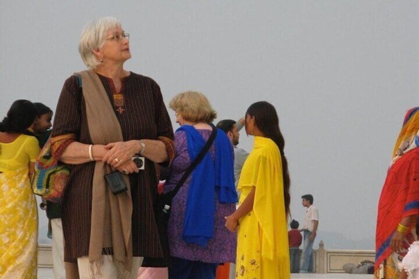 A group of people standing outdoors, some in traditional attire. 3