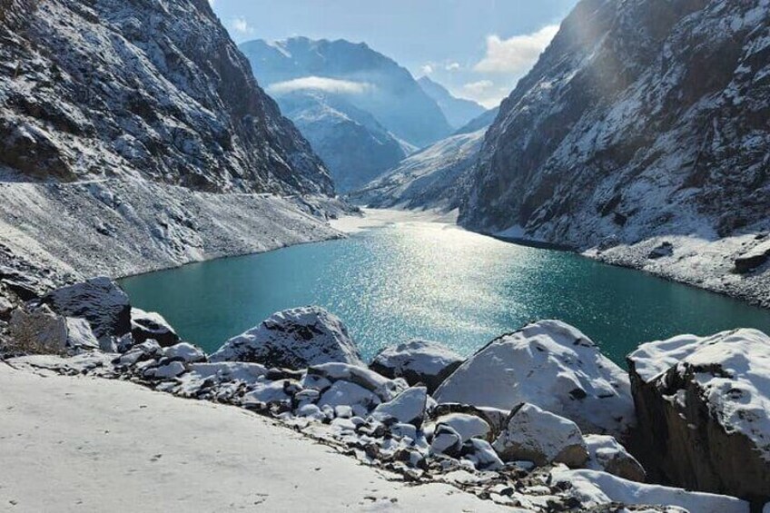 A snow-covered mountain landscape with a lake and rocky terrain. 4