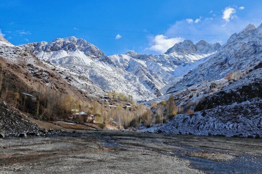 A snow-covered mountainous landscape with a small village and a river. 3