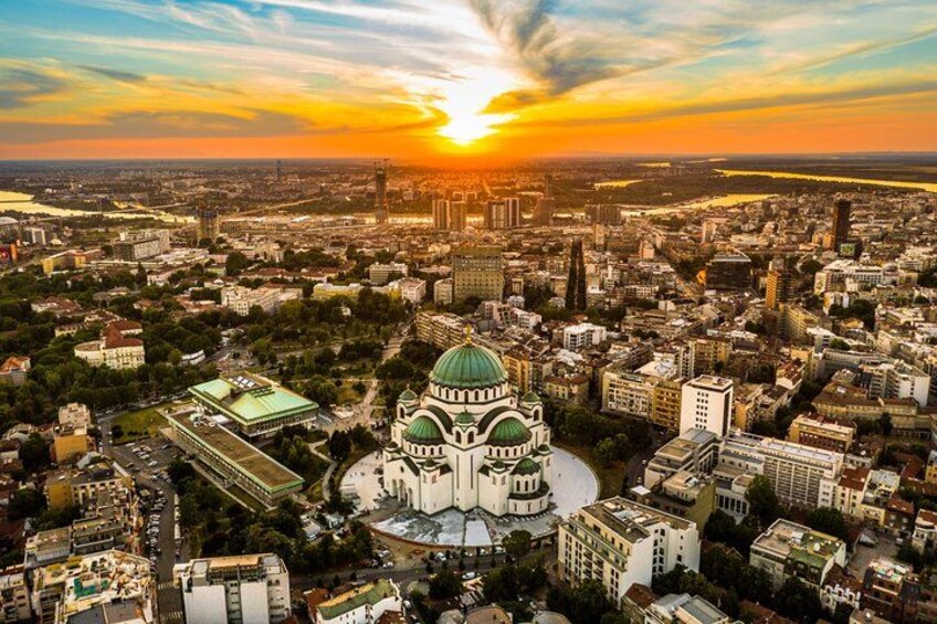A cityscape with a prominent green-domed building at the center, surrounded by dense urban development. 3