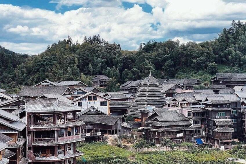 A traditional village with wooden houses and a pagoda. 1