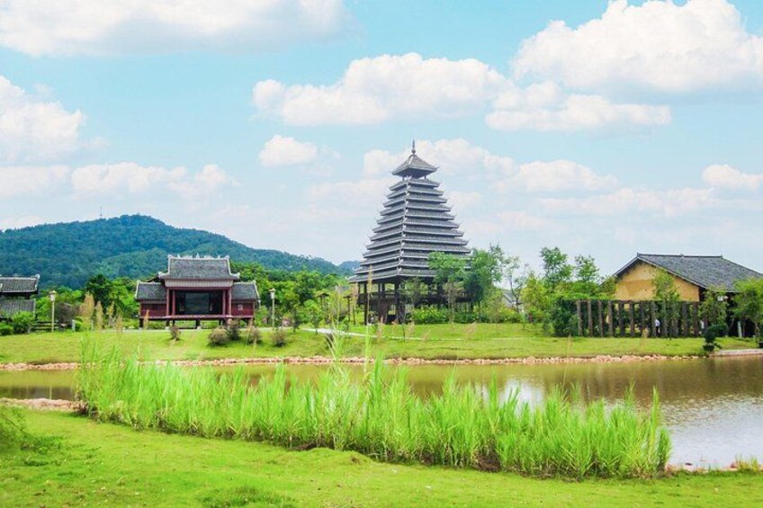 A traditional pagoda, a pond, and a small building in a landscaped area with grass and trees. 3