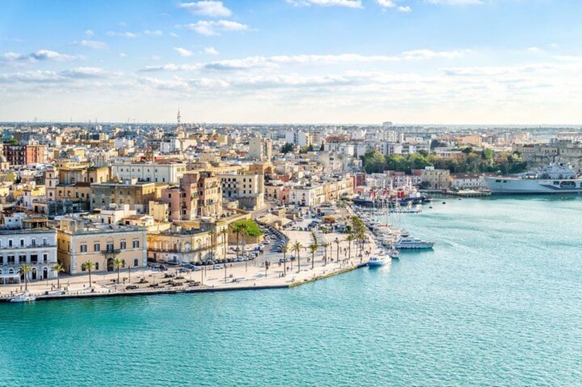 Un paysage urbain côtier avec un port de plaisance, des bâtiments et un ciel dégagé. 2