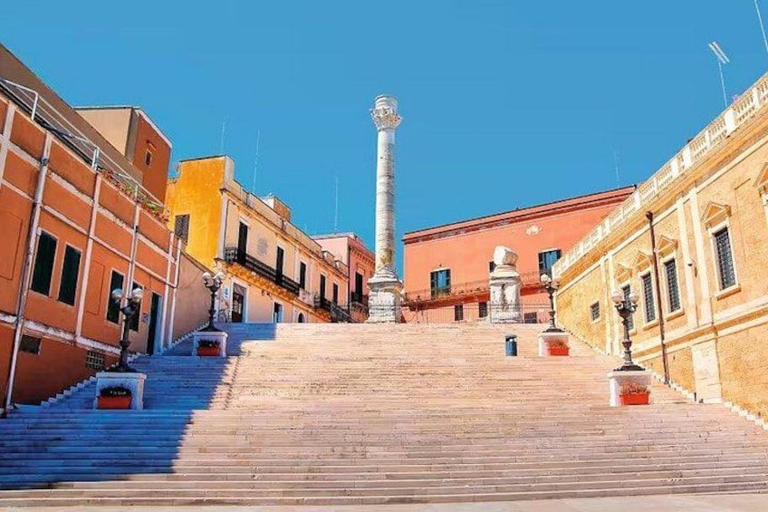 Un escalier menant à un monument situé sur une place de la ville, entourée de bâtiments. 3