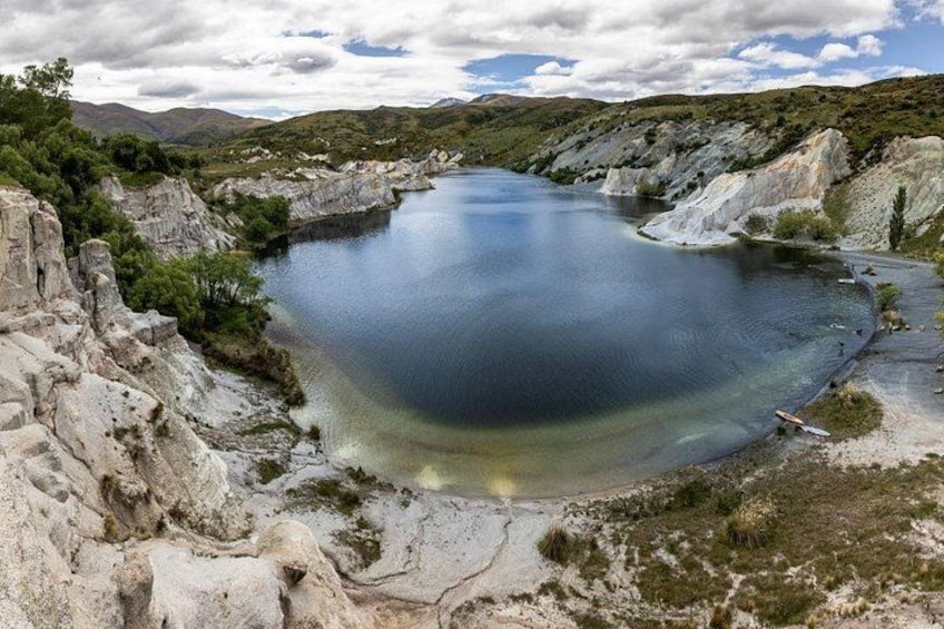 A lake surrounded by rocky terrain and sparse vegetation. 5