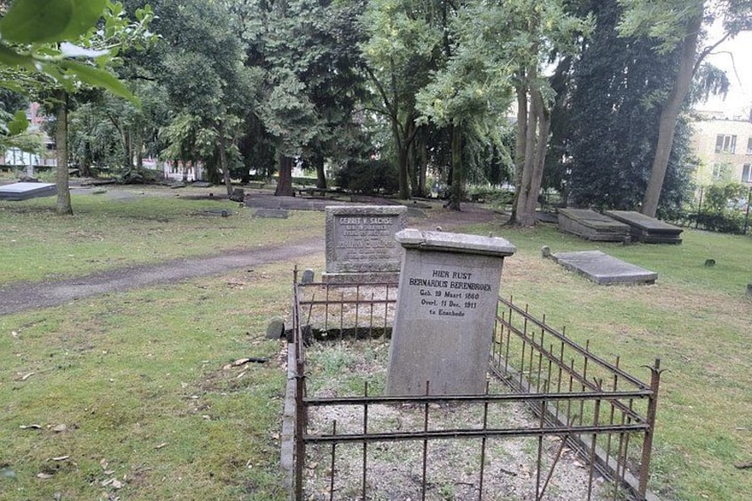A cemetery with tombstones and a metal fence. 3