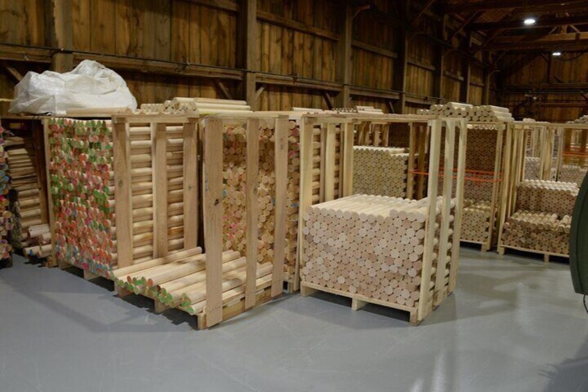 Des caisses en bois remplies d’objets colorés, probablement destinés au stockage ou à l’exposition, dans un entrepôt. 2