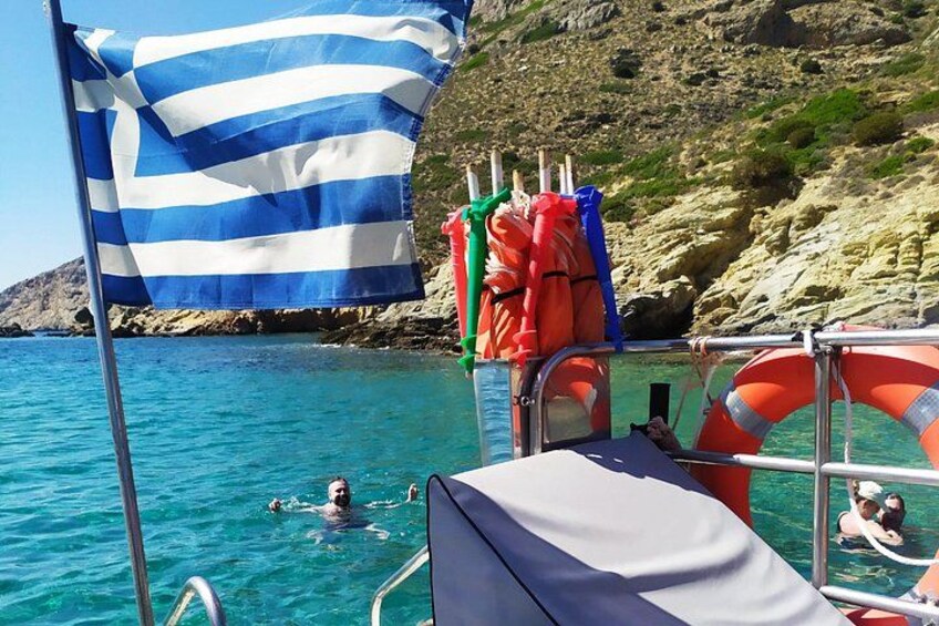 Una bandera, boyas salvavidas y gente nadando en aguas azules y cristalinas. 1