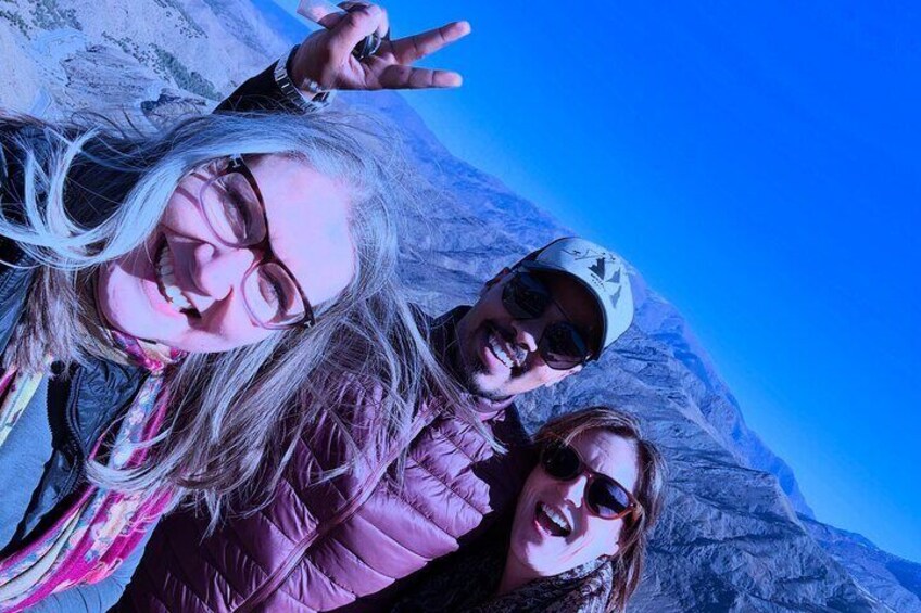 Three people taking a selfie with a mountainous background. 3