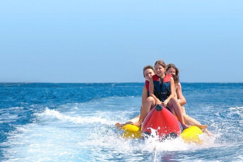 En person kører jetski med tre passagerer. 1