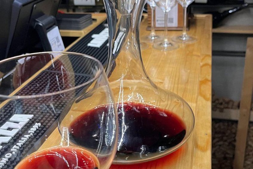 Eine Weinkaraffe und zwei Gläser mit Rotwein auf einem Holztisch. 1