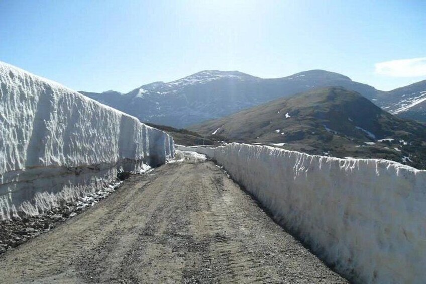 A snow-covered road with mountains in the background. 3