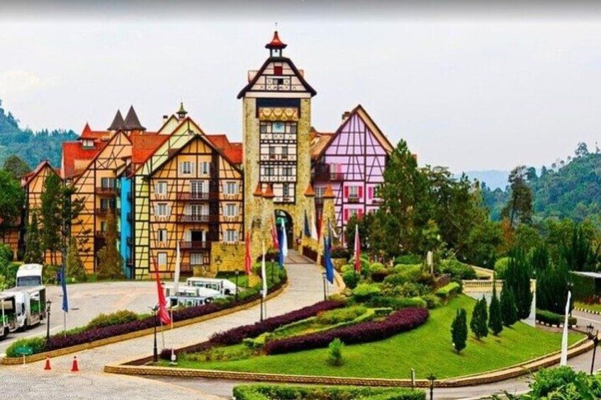 Un complejo de edificios coloridos con una torre central, rodeado de jardines y senderos bien cuidados. 3