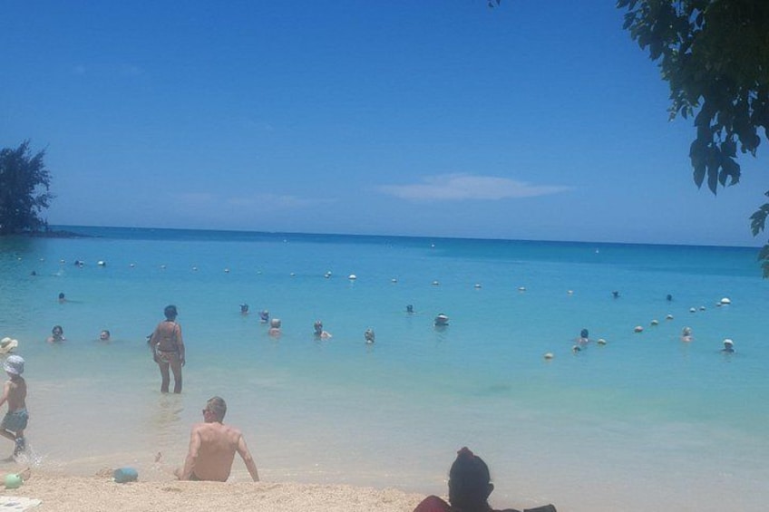 A beach with people swimming and playing in the water. 3