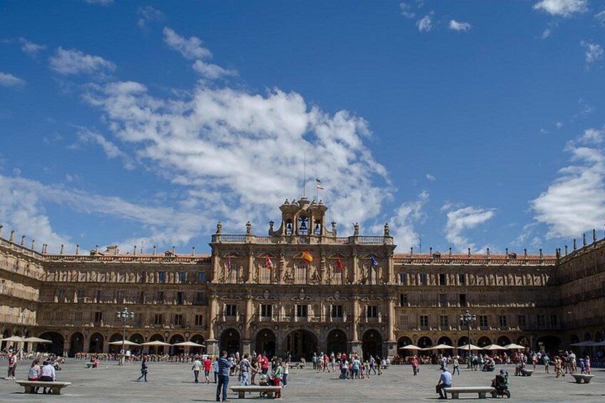 A historic building with a large open courtyard, arches, and a central tower. 4