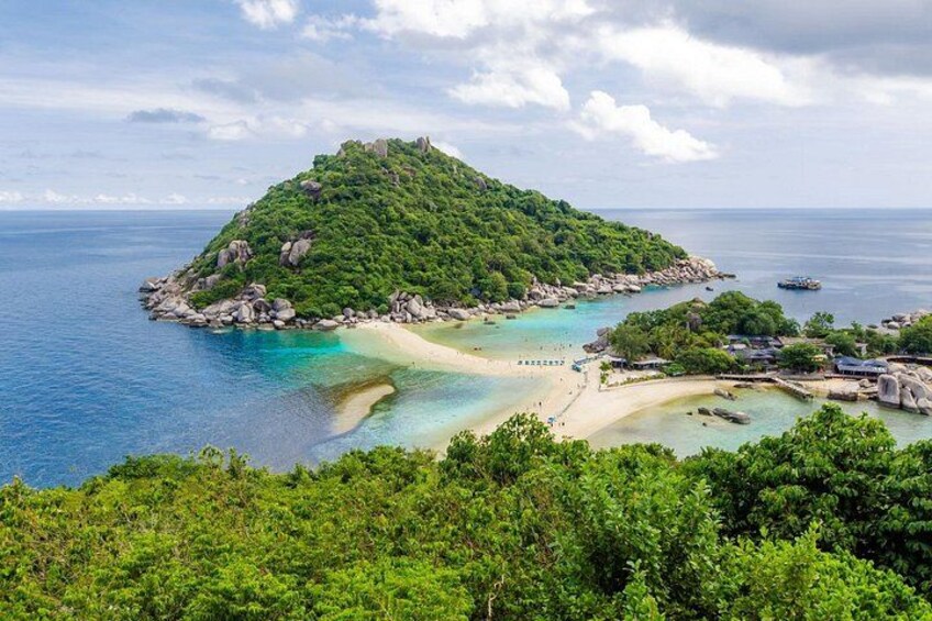 Un'isola verdeggiante con una spiaggia e acque cristalline. 2