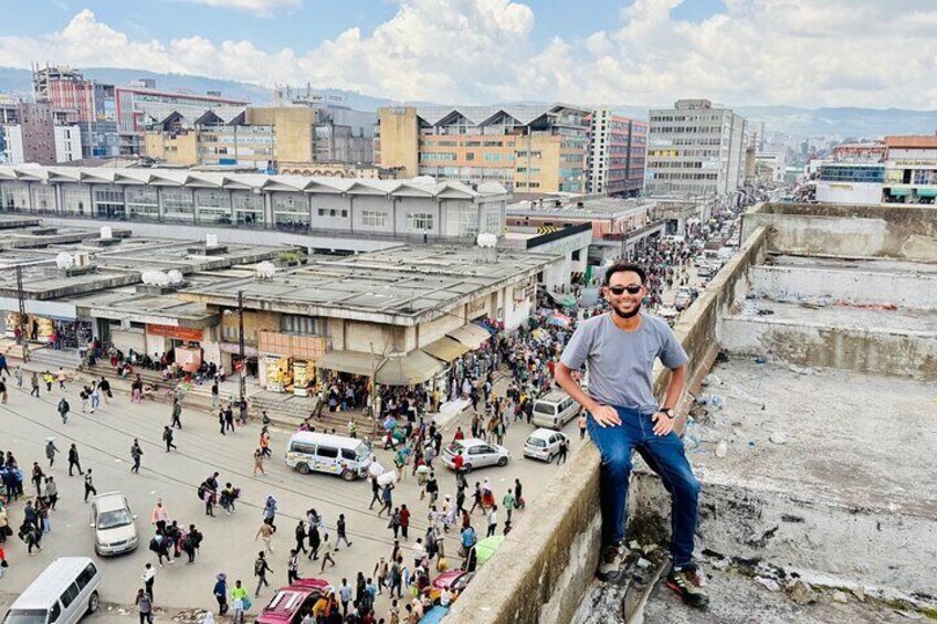 Una calle urbana concurrida, con una persona de pie sobre una barandilla de hormigón. 1