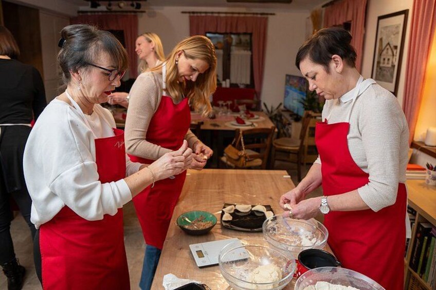 Three people in red aprons preparing food in a kitchen. 5