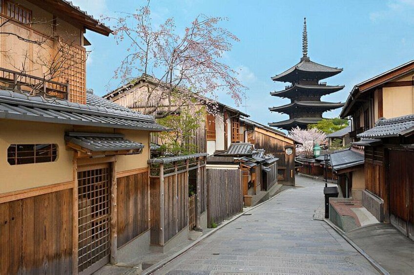 A traditional Japanese street with wooden houses, a pagoda, and cherry blossoms. 3