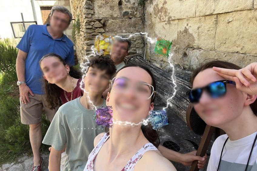 Un grupo de personas de pie al aire libre cerca de un muro de piedra. 4
