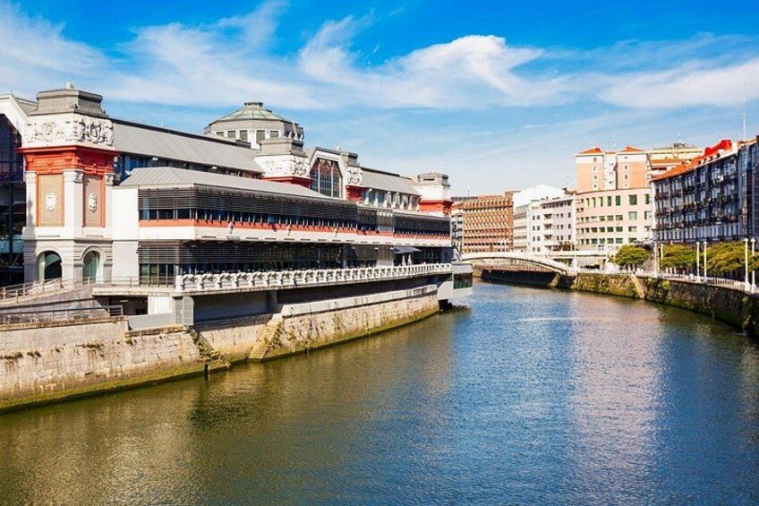 Ein Fluss mit einer Brücke und einem mehrstöckigen Gebäude mit rotem Dach. 4