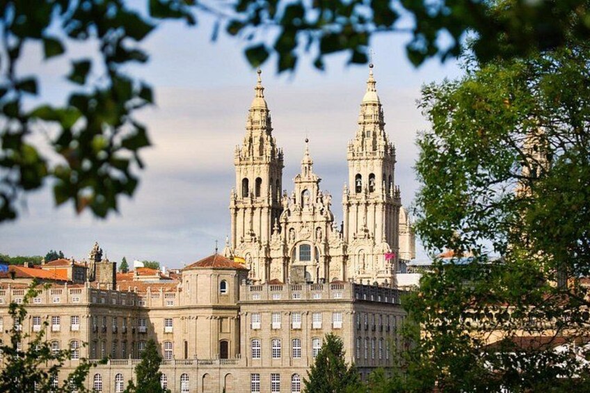 Eine historische Kathedrale mit zwei markanten Türmen, umgeben von Stadtgebäuden und Bäumen. 1