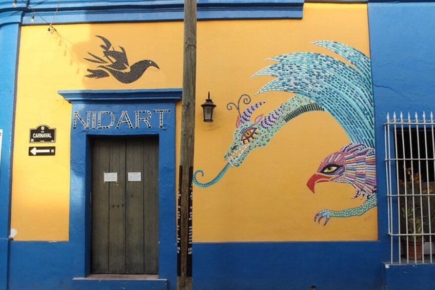 A building with a mural of a peacock and a sign that reads 'NIDART.' 4
