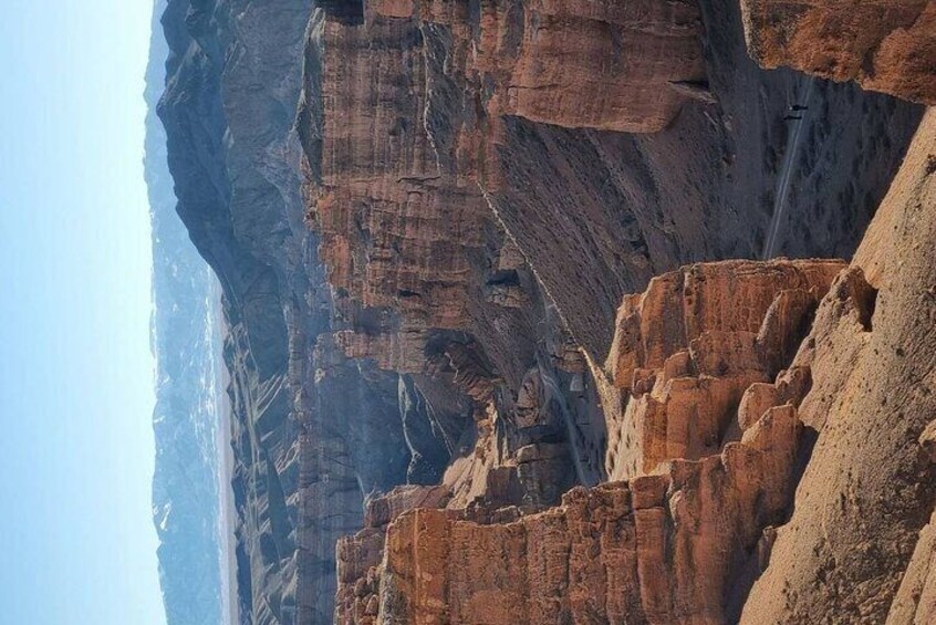 Een canyon met gelaagde rotsformaties en een heldere lucht. 5