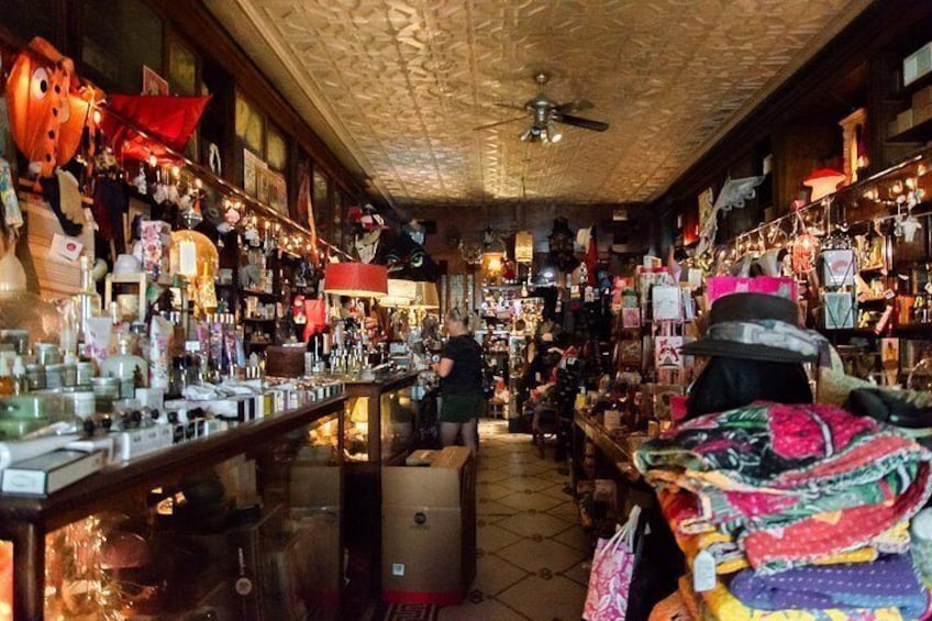 A cluttered indoor market with various stalls and items on display. 3