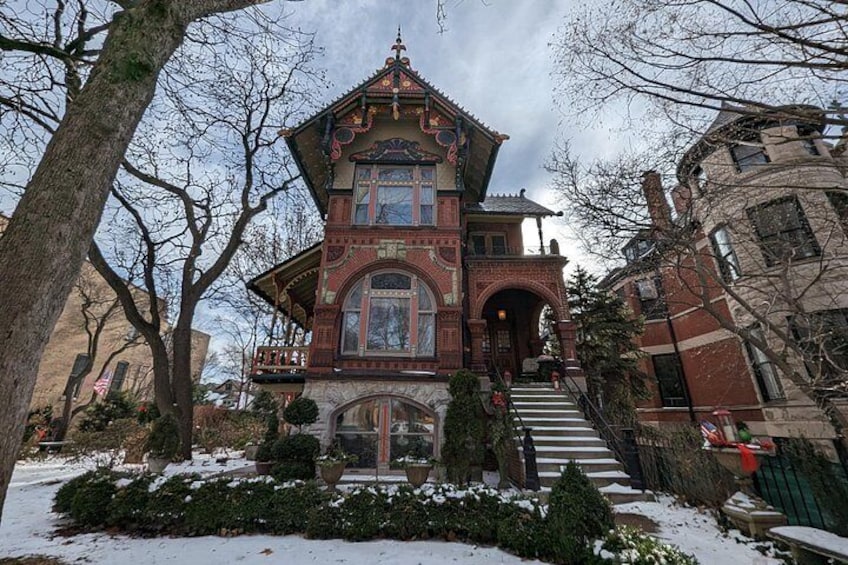 A Victorian-style house with a steeply pitched roof, a front porch, and a snow-covered yard. 4