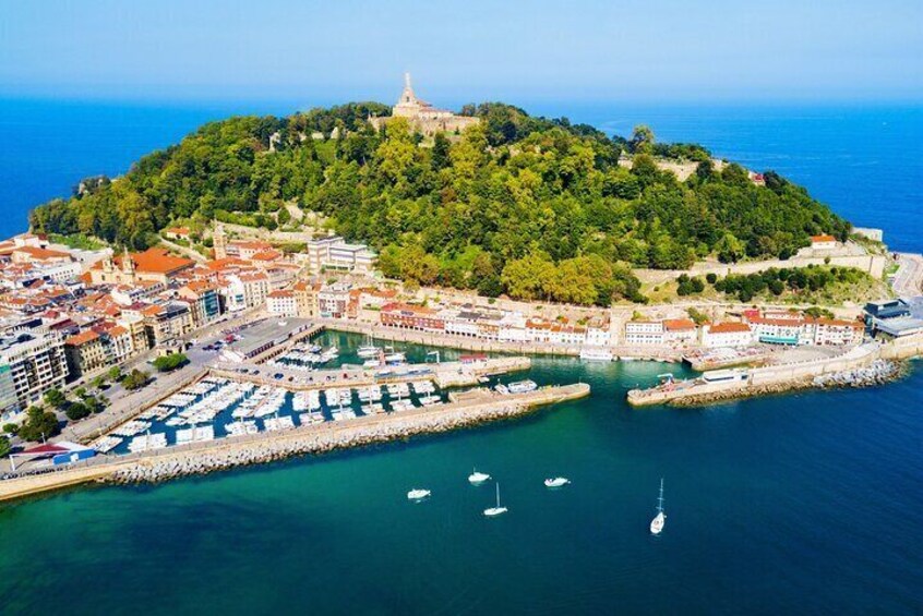 A coastal town with a marina, boats, and a hilltop fortress. 1