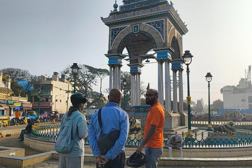 Un gruppo di persone vicino a un monumento storico con un arco decorativo. 2