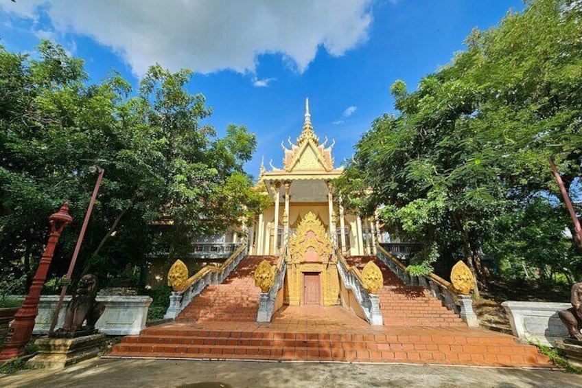 A temple with a golden spire, surrounded by trees and a brick staircase leading up to it. 4