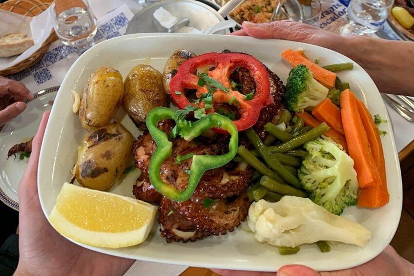 En tallerken mad med kød, grøntsager og et stykke citron. 4