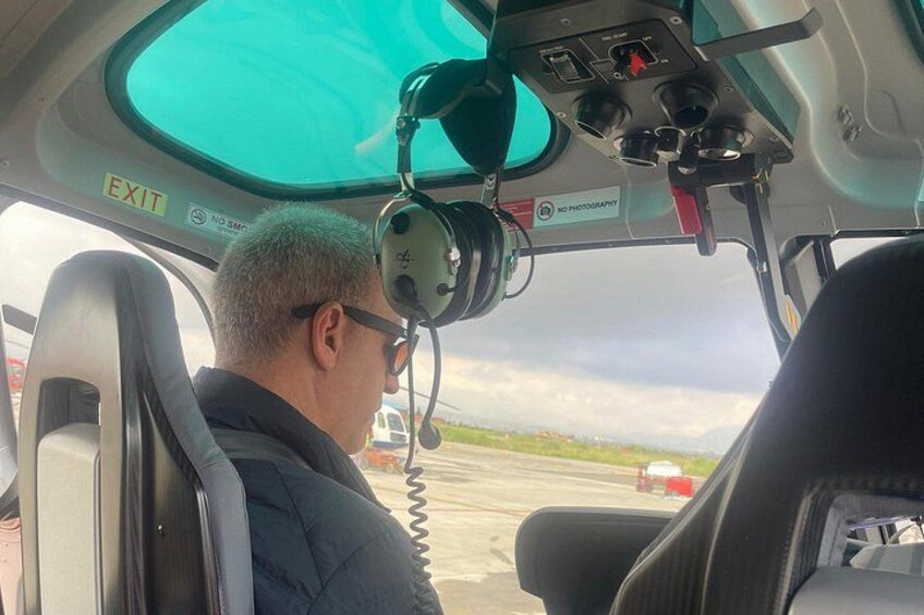 A helicopter cockpit with a view of the runway and surrounding landscape. 4