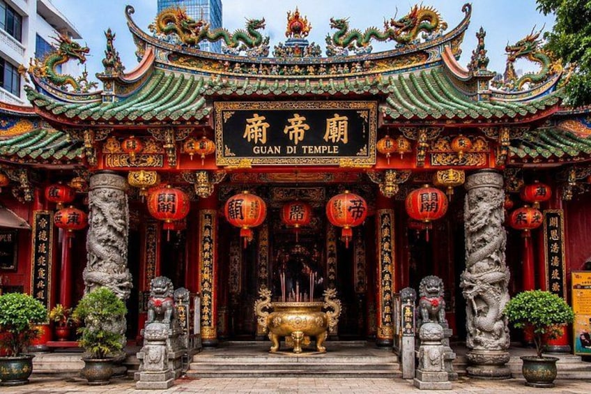 A traditional Chinese temple with ornate architecture, including a dragon motif on the roof and a large incense burner in the center. 5