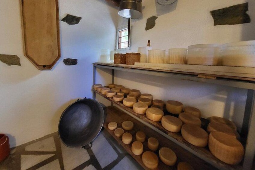 Een kaasopslagruimte met houten planken en een grote zwarte pan. 4