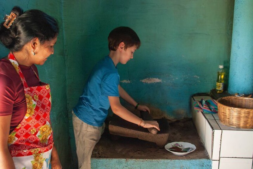 Grinding coffee with volcanic stone at coffee producer's house 3