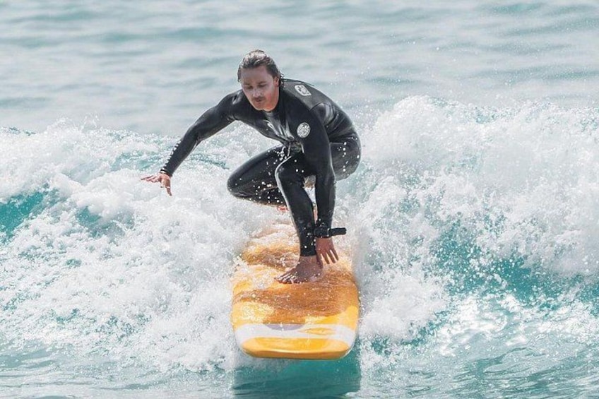 A person surfing on a yellow surfboard. 1