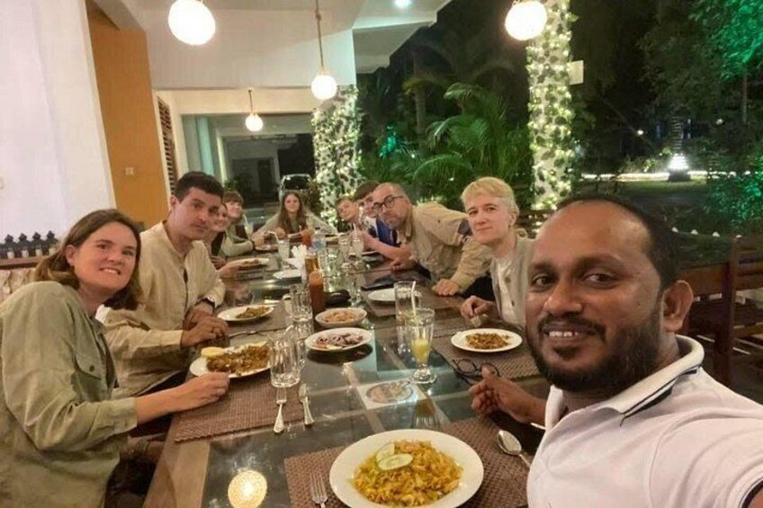A group of people dining at a restaurant with a view of a garden. 4