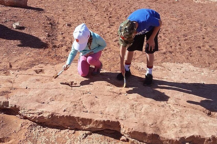 Two people examining a rock formation in a desert. 5
