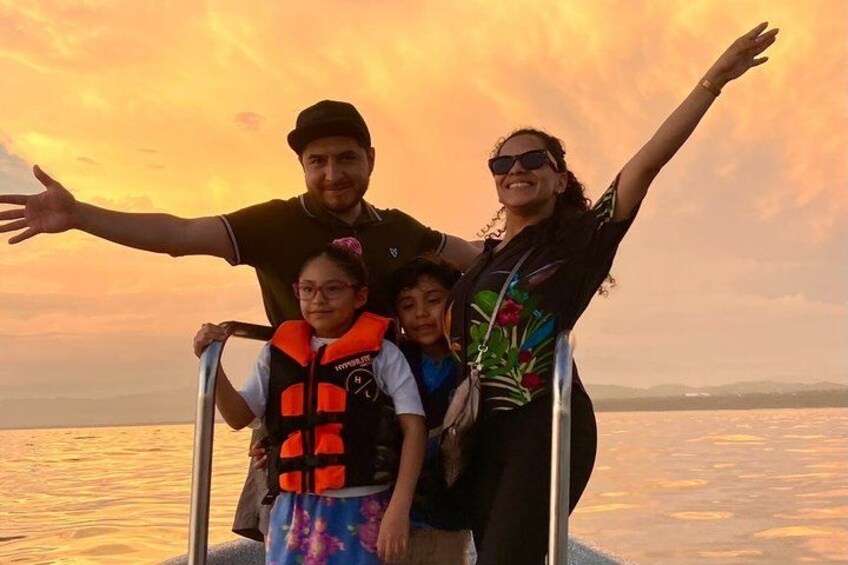 A family on a boat with a sunset in the background. 4
