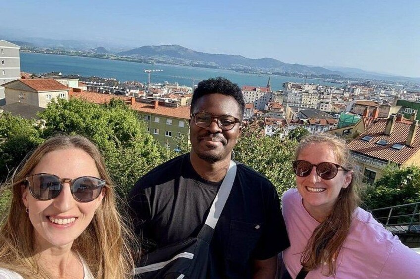 Drei Personen posieren vor einer malerischen Stadtlandschaft. 2