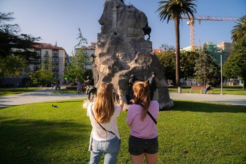 Zwei Personen fotografieren eine Felsformation mit Statuen. 4