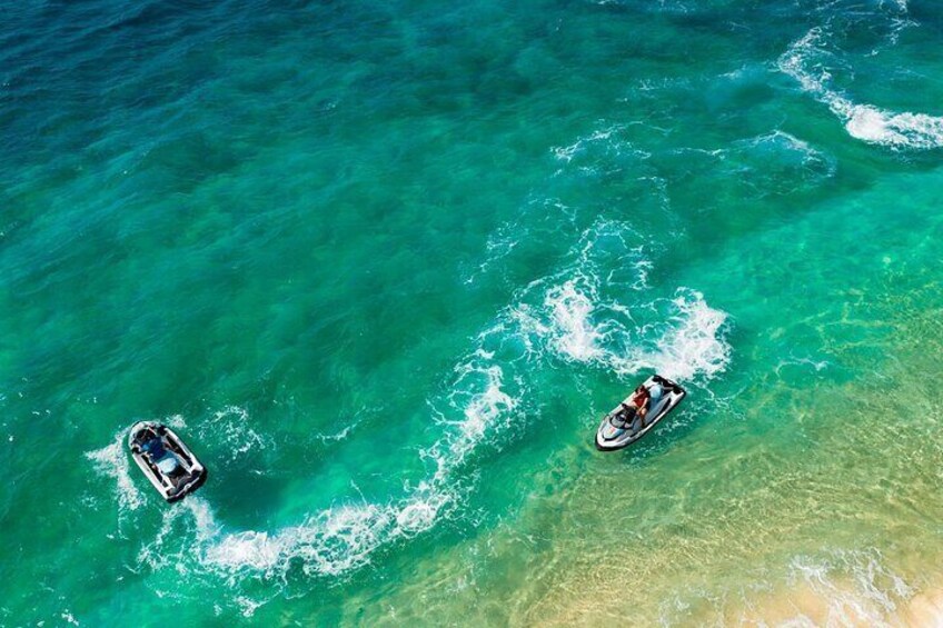 Two boats on turquoise water near a sandy beach. 5